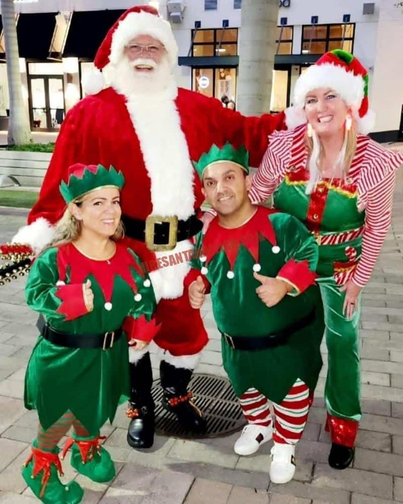 Daycare Santa with elves in green costumes ready for a school party line