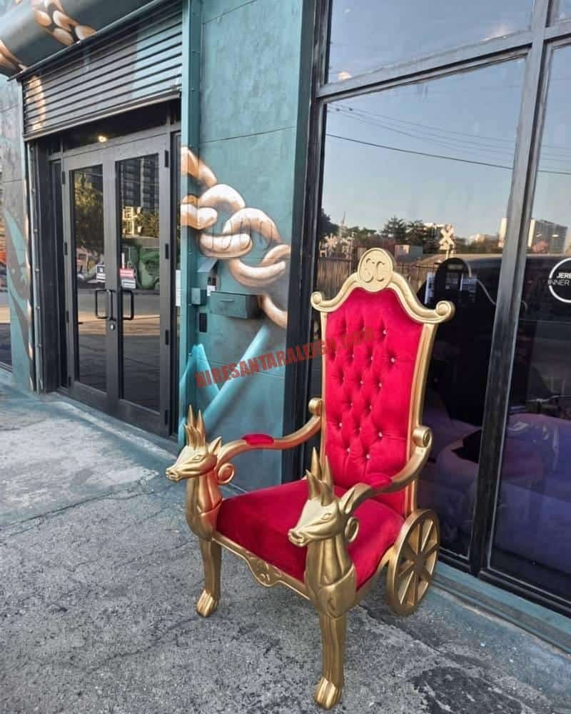Santa chair photos throne with gold reindeer armrests outside a glass storefront